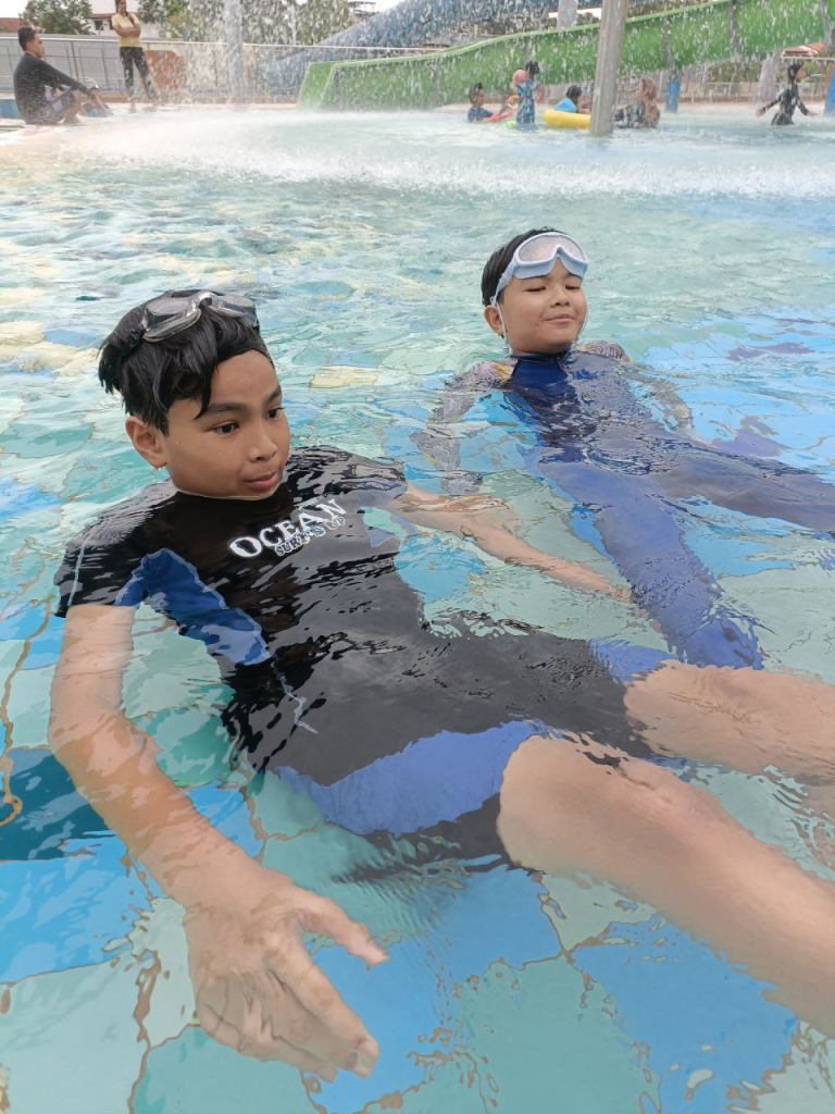 2 boys chilling in pool shallow waters to build confidence